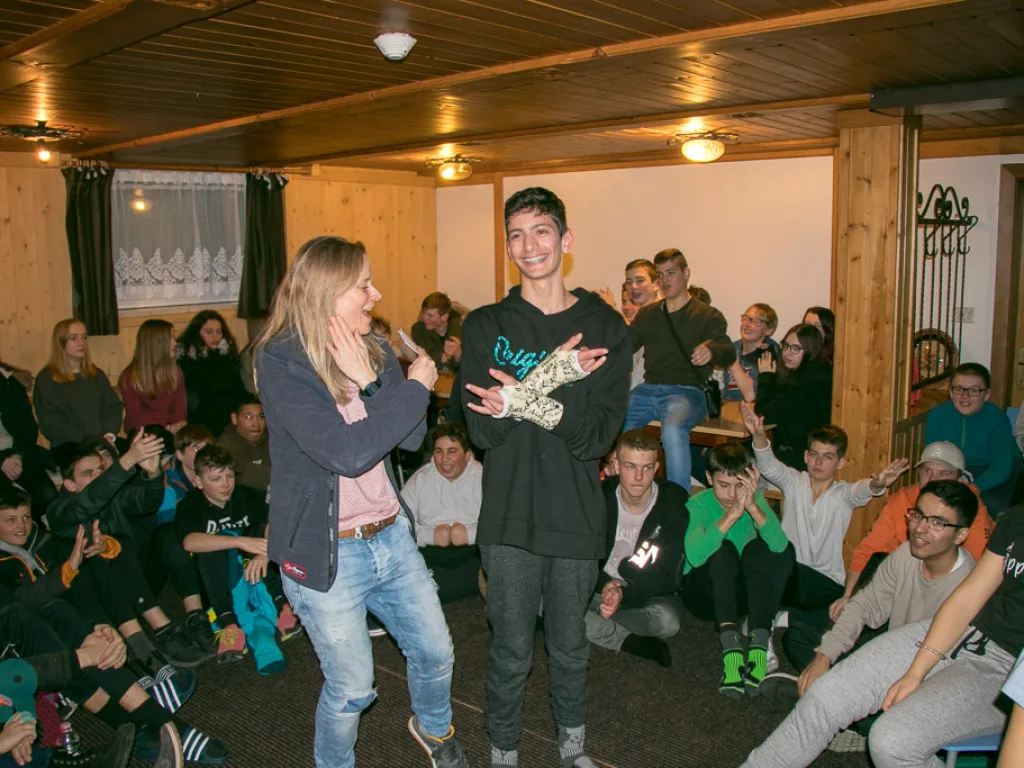 Zwei Jugendliche stehen vor der Gruppe im Aufenthaltsraum.
